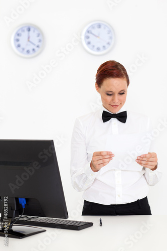 Photo: young woman working at hotel reception young woman working at hotel reception