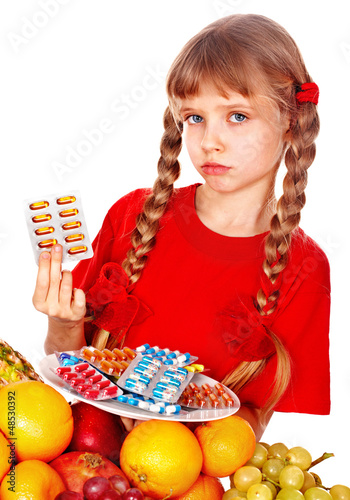 Photo: Child with fruit and vitamin pill. Child with fruit and vitamin pill.