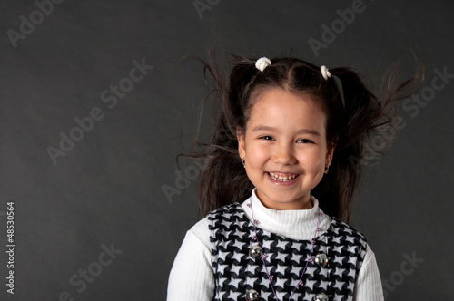 Photo: charming girl with flying hair and dimples on her cheeks charming girl with flying hair and dimples on her cheeks