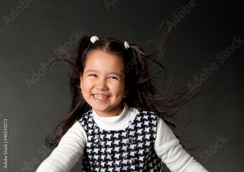 Photo: charming girl with flying hair and dimples on her cheeks charming girl with flying hair and dimples on her cheeks