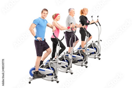 Photo: A group of people working on a cross trainer machine A group of people working on a cross trainer machine