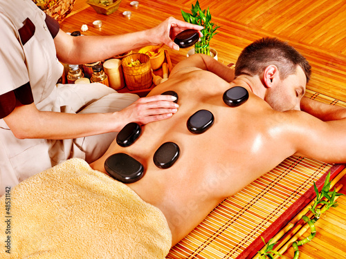 Photo: Man getting stone therapy massage . Man getting stone therapy massage .
