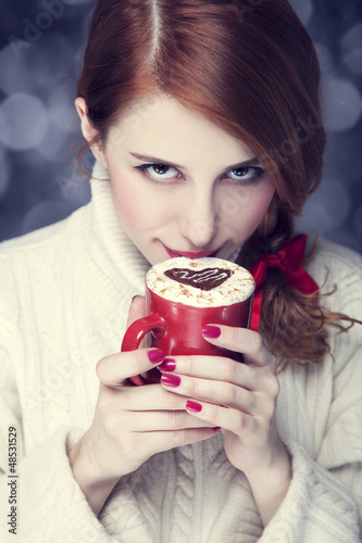 Photo: Redhead girl with red coffee cup. St. Valentine Day Redhead girl with red coffee cup. St. Valentine Day