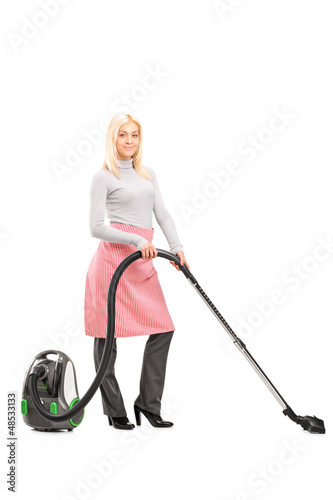 Photo: Full length portrait of a blond housewife cleaning with a vacuum Full length portrait of a blond housewife cleaning with a vacuum