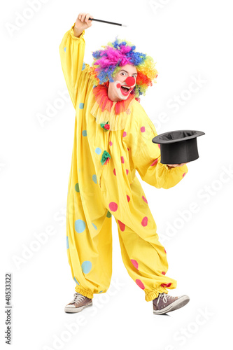 Photo: Full length portrait of a circus clown performing a magic trick Full length portrait of a circus clown performing a magic trick