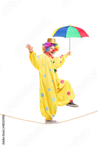 Photo: Happy male clown with umbrella walking on a rope Happy male clown with umbrella walking on a rope