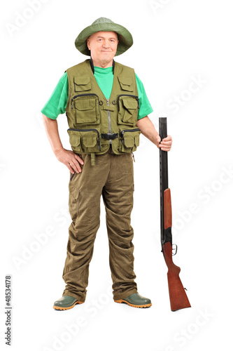 Photo: Full length portrait of a male hunter holding a shotgun Full length portrait of a male hunter holding a shotgun