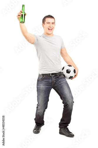 Photo: Euphoric sport fan holding a beer bottle and football Euphoric sport fan holding a beer bottle and football
