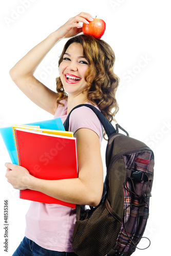 Photo: Happy female student with red apple above her head isolated on w Happy female student with red apple above her head isolated on w