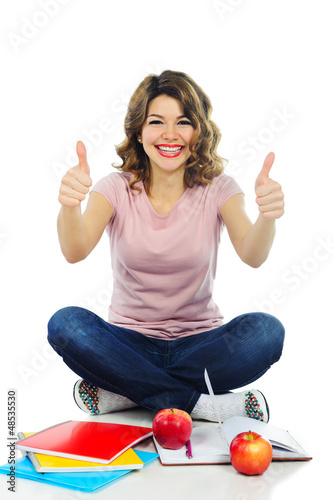 Photo: Happy female student showing thumbs up isolated on white Happy female student showing thumbs up isolated on white
