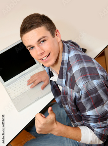 Photo: Student with laptop showing thumb up Student with laptop showing thumb up