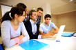 Teacher with students in class working on laptop