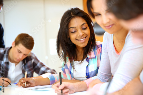 Photo: Group of teenagers in class writing an exam Group of teenagers in class writing an exam