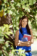 Student portrait at school, happy young woman with university bo