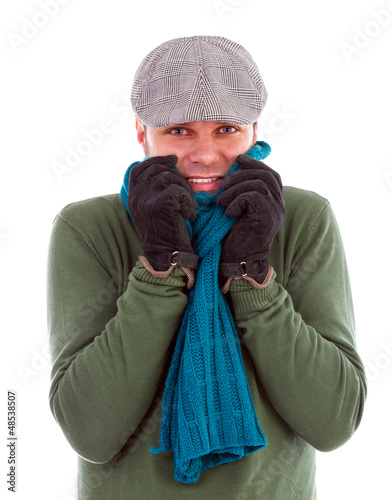 Photo: Young man with gloves and scarf shivering from cold Young man with gloves and scarf shivering from cold