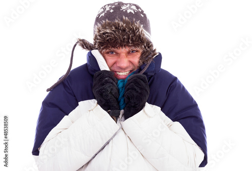 Photo: Young man with hat and coat shivering from cold Young man with hat and coat shivering from cold