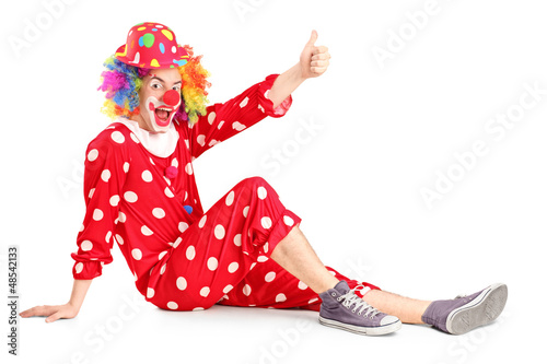 Photo: A clown with smiling joyful expression sitting down and giving t A clown with smiling joyful expression sitting down and giving t