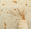 Background texture of baked lavash bread and ears of wheat