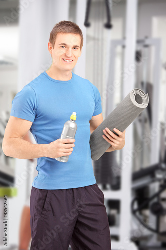 Photo: Male posing with refreshment and a mat after an excerise at the Male posing with refreshment and a mat after an excerise at the
