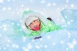 Cheerful girl lying in deep snow drift