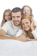 Foto: family smiling while laying on bed covered with white linen family smiling while laying on bed covered with white linen