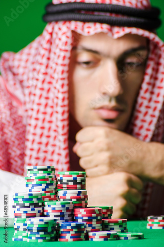 Photo: Arab playing in casino - gambling concept with man Arab playing in casino - gambling concept with man