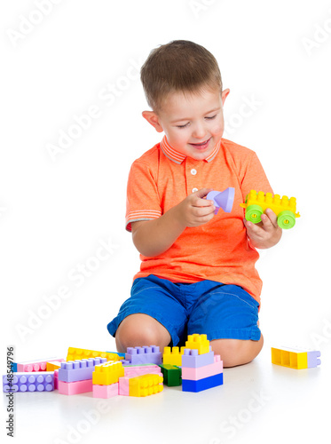 Photo: cheerful child boy playing with construction set over white back cheerful child boy playing with construction set over white back