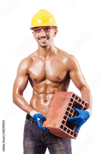 Photo: Muscular builder with bricks on white Muscular builder with bricks on white