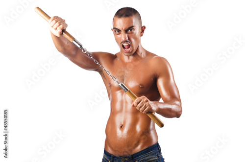 Photo: Man in martial arts concept with nunchucks Man in martial arts concept with nunchucks