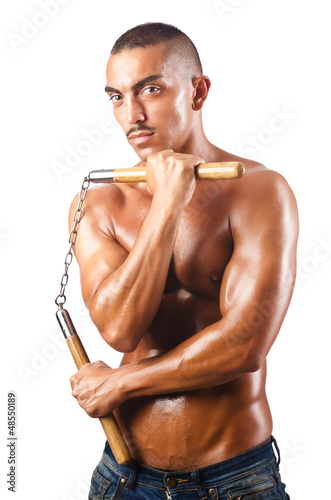 Photo: Man in martial arts concept with nunchucks Man in martial arts concept with nunchucks