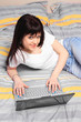 girl in her bed looking using her laptop