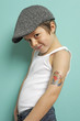 Kind posiert mit Tattoo und Kappe