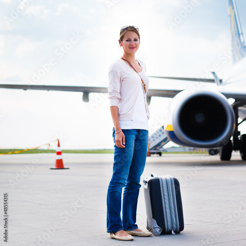 Photo: Just arrived: young woman at an airport having just left the air Just arrived: young woman at an airport having just left the air