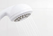 Water flowing from bathroom plastic white shower head