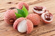 Lychee with leaves on a wooden table.