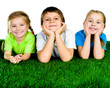 Photo: boy and girls lying on a green grass boy and girls lying on a green grass