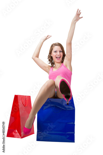 Photo: Nice girl sitting on the shopping bag. Nice girl sitting on the shopping bag.
