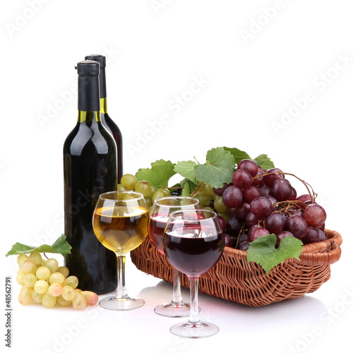 Photo: bottles and glasses of wine and grapes in basket, isolated bottles and glasses of wine and grapes in basket, isolated