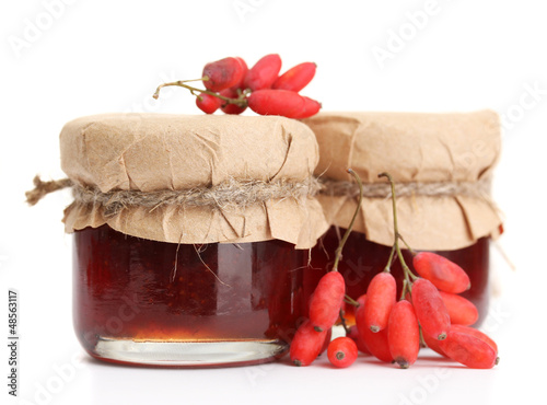 Photo: ripe barberries and jars of jam isolated white ripe barberries and jars of jam isolated white