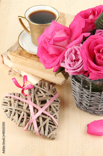 Photo: Beautiful pink roses in vase on wooden table close-up Beautiful pink roses in vase on wooden table close-up