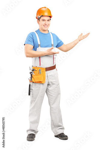 Photo: Full length portrait of a manual worker with tool belt and helme Full length portrait of a manual worker with tool belt and helme