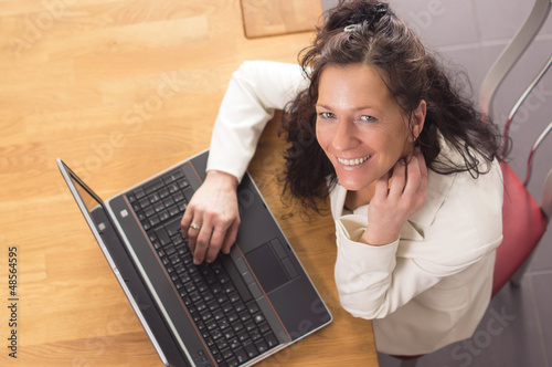 Photo: Smiling Woman with Notebook looking up Smiling Woman with Notebook looking up