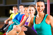 Group of people and instructor in gym stretching