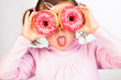 Photo: Girl looks through donuts Girl looks through donuts