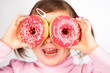Photo: Girl looks through donuts Girl looks through donuts