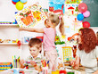 Child painting at easel.