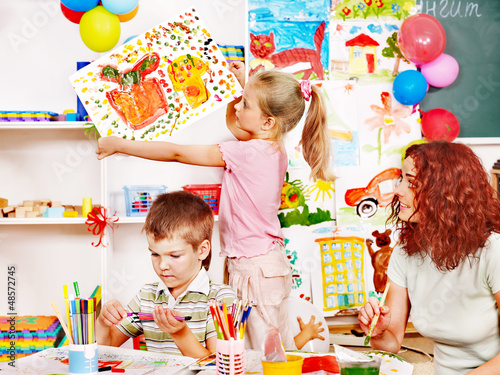 Photo: Child painting at easel. Child painting at easel.
