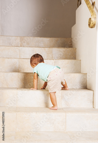 Photo: Little girl climbing steps at home Little girl climbing steps at home