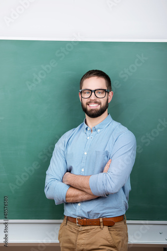 Photo: lächelnder mann mit brille steht vor der tafel lächelnder mann mit brille steht vor der tafel