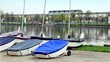 Several boats lay near pond,city traffic on background